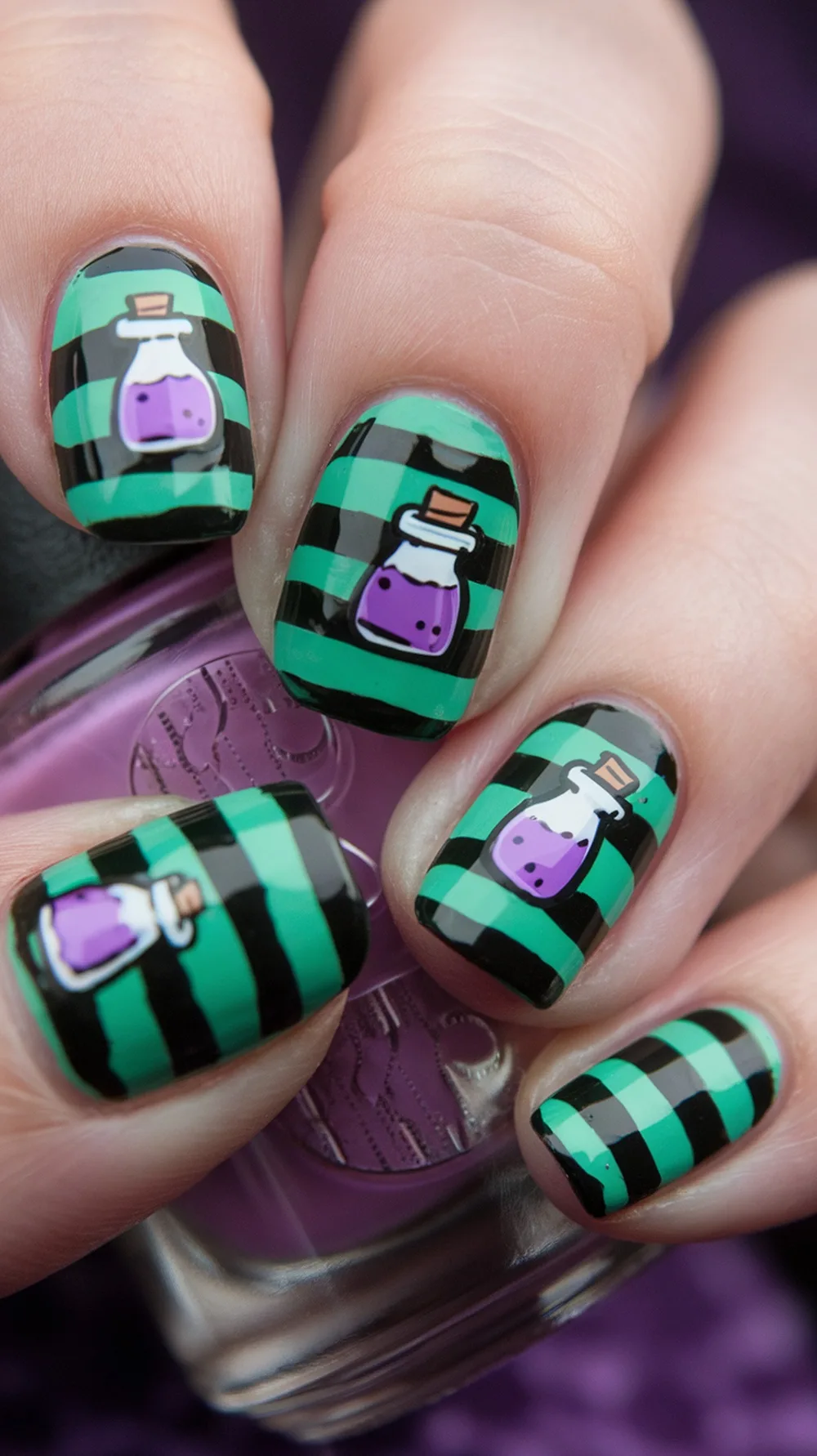 Nail design featuring green and black striped pattern with potion bottle illustrations.