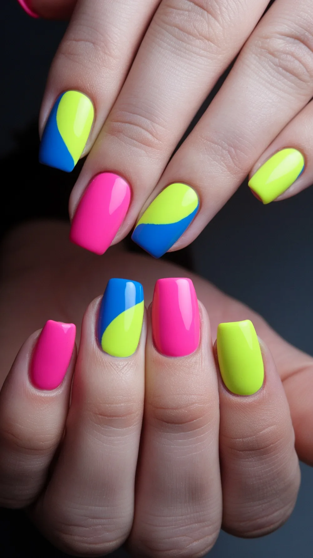 Color block nails featuring bright pink, neon yellow, and electric blue designs.
