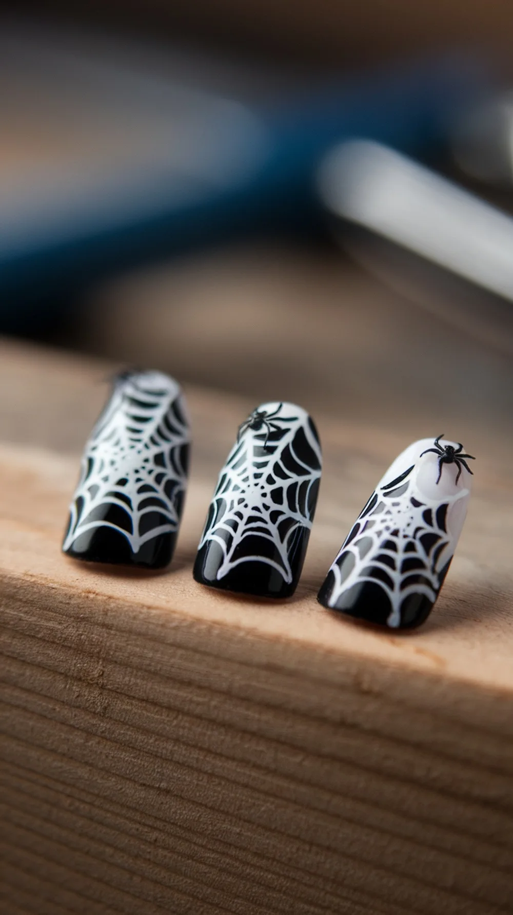 Nail designs featuring spider webs in black and white.