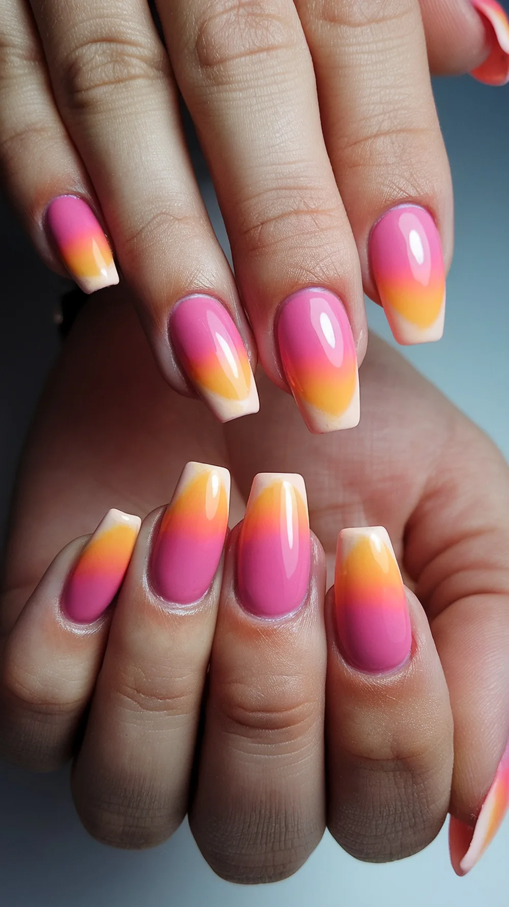 Close-up of sunset ombre nails featuring pink and orange gradient colors.